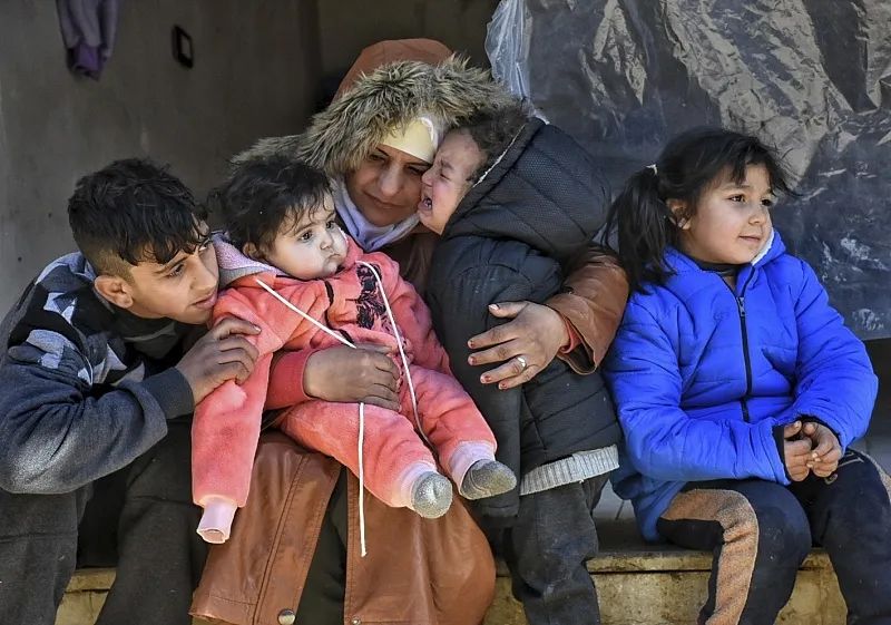 当地时间2月9日，叙利亚阿勒颇，住在临时营地的一家人