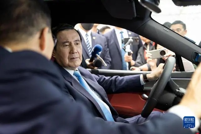 马英九先生在重庆市赛力斯汽车两江智慧工厂车间内试乘汽车